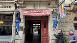 Nikolausmarkt im Kunsthof Gewerbetreibende beim Aufhängen des Nikolausmarkt-Banners - Foto: Anton Launer