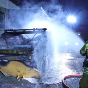 Ein Feuerwehrmann der Berufsfeuerwehr Dresden löscht in der Nacht zum 2. Juni den brennenden Bauschuttcontainer am Neustädter Markt. Foto: Roland Halkasch