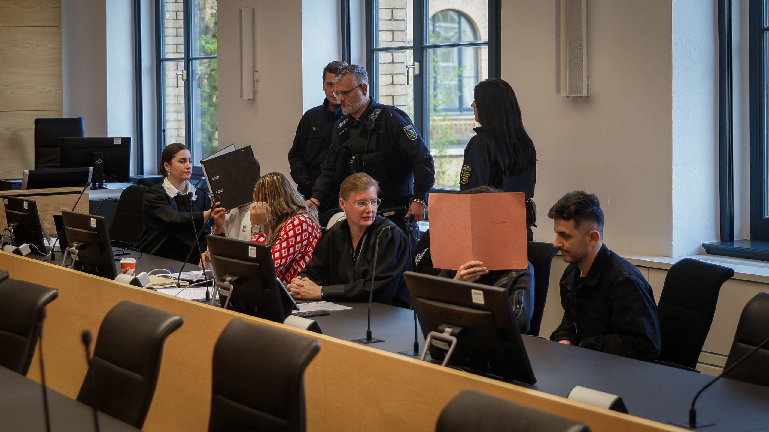 Die Angeklagten Majd A. (links) und Ismail H. (rechts) verdeckt von Aktenordnern auf der Anklagebank mit ihren Verteidigerinnen.  Foto: Florian Varga